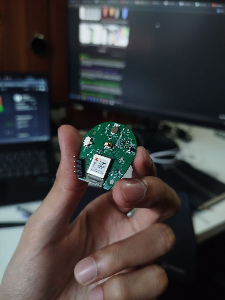 Round wireless wearable PCB with RF module and header pins, assembled board held in hand