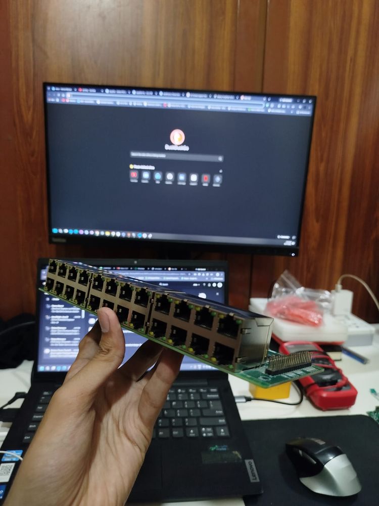 Multi-port Ethernet switch board with a row of RJ45 jacks, assembled PCB held in hand